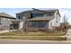 Attractive modern home with a combination of stone and siding, a well-maintained lawn, and mature trees at 8172 S Langdale Way, Aurora, CO 80016