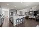 Spacious open kitchen featuring a large island with seating, modern appliances, and seamless flow to living area at 8172 S Langdale Way, Aurora, CO 80016