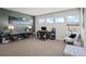 A well-lit home office features dual work stations, a comfortable chair, and abundant natural light from three windows at 8172 S Langdale Way, Aurora, CO 80016