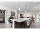 Open concept kitchen with quartz island featuring an oven and opening to living room and staircase at 8958 Southurst St, Littleton, CO 80129