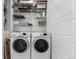 Bright laundry room featuring washer, dryer, shelving, and storage space at 8958 Southurst St, Littleton, CO 80129