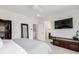 Bright main bedroom boasts a walk-in closet, ceiling fan, and a wall-mounted television at 8958 Southurst St, Littleton, CO 80129