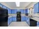 Functional kitchen with blue cabinets, black appliances, and ample counter space at 1282 S Troy St, Aurora, CO 80012