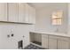 Laundry room with white cabinets, countertop, sink, and patterned tile at 2525 Lupton Ln, Lafayette, CO 80026