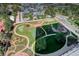 Aerial view of landscaped community grounds with paths, putting green, and tennis court at 3131 E Alameda Ave # 1003, Denver, CO 80209