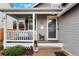 Inviting front porch featuring white railings, a cozy porch swing, and decorative accents, creating a welcoming entrance at 21733 Saddlebrook Dr, Parker, CO 80138