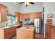 Well-lit kitchen with wood cabinets, stainless steel appliances, an island, and a window overlooking the backyard at 21733 Saddlebrook Dr, Parker, CO 80138
