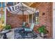 Cozy patio with rocking chairs, an umbrella, and planters by a brick wall, unit marked as 1D at 2428 W 82Nd Pl # 1D, Westminster, CO 80031