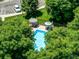 Aerial view of a sparkling pool surrounded by lush trees, sunbathers, and umbrellas at 2428 W 82Nd Pl # 1D, Westminster, CO 80031