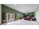 Spacious basement with green accent wall and access to patio at 8174 Inca Rd, Larkspur, CO 80118