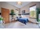 Bright bedroom featuring a trundle bed with blue comforter and views of the surrounding wooded area at 8174 Inca Rd, Larkspur, CO 80118