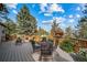 Spacious deck with seating and scenic views of the surrounding trees and landscape at 8174 Inca Rd, Larkspur, CO 80118