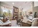 Open-concept living room with a stone fireplace, comfortable seating, and an adjacent kitchen at 8174 Inca Rd, Larkspur, CO 80118