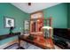 Home office with wood desk, large window, and view into kitchen at 8174 Inca Rd, Larkspur, CO 80118