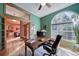 Home office with wood desk and view into adjacent kitchen at 8174 Inca Rd, Larkspur, CO 80118