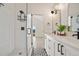 Bathroom featuring a glass-enclosed shower with white tile and a dual sink vanity at 1907 W Elk Pl, Denver, CO 80211