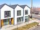 Modern townhome exterior featuring clean lines, a stylish facade, a sidewalk, and a small yard at 1907 W Elk Pl, Denver, CO 80211