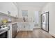 Modern kitchen with stainless steel appliances, white cabinetry, and hardwood flooring at 1907 W Elk Pl, Denver, CO 80211