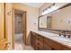 Bathroom with double vanity, granite countertops, wood cabinets, large mirror, and tiled backsplash at 8286 W 108Th Pl, Broomfield, CO 80021