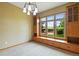 Cozy living room featuring built-in cabinets, large windows with backyard views, and a chandelier at 8286 W 108Th Pl, Broomfield, CO 80021