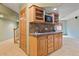 A close-up of the wet bar area with wooden cabinets, sink, and a microwave in the basement at 8286 W 108Th Pl, Broomfield, CO 80021