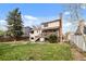 Large backyard with mature trees and a covered deck off of the house, perfect for outdoor activities and relaxation at 9911 Perry Ct, Westminster, CO 80031