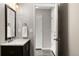 Modern bathroom with stylish vanity, fixtures, and a view into the hallway and entry door at 9911 Perry Ct, Westminster, CO 80031