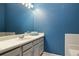 The bathroom features a vanity with gray cabinets, a white countertop, and a blue wall at 9911 Perry Ct, Westminster, CO 80031