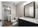 Stylish bathroom featuring a black vanity, sleek mirror, and a door to the laundry area at 9911 Perry Ct, Westminster, CO 80031