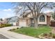A quaint two-story home with a well-manicured lawn and blooming tulips, showcasing classic suburban charm with a two-car garage at 9911 Perry Ct, Westminster, CO 80031