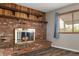 Close-up of the brick fireplace with wood mantel and shelving, offering a warm focal point at 9911 Perry Ct, Westminster, CO 80031