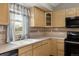 Close-up on a kitchen featuring wood cabinets, a window, and stainless steel appliances at 9911 Perry Ct, Westminster, CO 80031