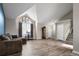 Spacious living room featuring vaulted ceilings, large arched window, and staircase access at 9911 Perry Ct, Westminster, CO 80031