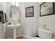Bathroom featuring a pedestal sink, toilet, and decorative art, enhancing the space's appeal at 3548 W 126Th Pl, Broomfield, CO 80020