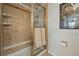 Tiled bathroom featuring a glass enclosed shower with gold trim and a neutral color palette at 3548 W 126Th Pl, Broomfield, CO 80020