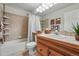 Bathroom featuring a tiled bathtub, wood vanity, and ample lighting and mirror at 3548 W 126Th Pl, Broomfield, CO 80020