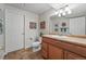 A well-lit bathroom boasts a wood vanity, neutral walls, and framed decorative art at 3548 W 126Th Pl, Broomfield, CO 80020