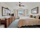 Bright bedroom with ensuite, dark wood furniture, ceiling fan and large window at 3548 W 126Th Pl, Broomfield, CO 80020