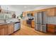 Kitchen area boasts stainless steel appliances, stone countertops, and beautiful wood flooring at 3548 W 126Th Pl, Broomfield, CO 80020