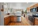 Well-lit kitchen features stainless steel appliances, stone countertops, and wood flooring at 3548 W 126Th Pl, Broomfield, CO 80020