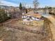 Aerial view of a home's backyard featuring a stone patio with seating, fire pit, and a perimeter fence at 14290 W 54Th Ave, Arvada, CO 80002
