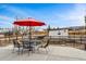 Back patio with a dining set and a red umbrella, overlooking the fenced yard at 14290 W 54Th Ave, Arvada, CO 80002