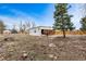 View of a barn in a large fenced-in yard, with a horse and person visible at 14290 W 54Th Ave, Arvada, CO 80002