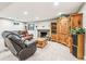 Basement living area with a brick fireplace, wood entertainment center and comfortable seating at 14290 W 54Th Ave, Arvada, CO 80002