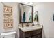 Bathroom vanity features a granite countertop, undermount sink, bronze fixtures, and decorative wall art at 14290 W 54Th Ave, Arvada, CO 80002