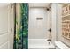 Bathroom showcasing a tub and shower with decorative curtain and accent tile design at 14290 W 54Th Ave, Arvada, CO 80002