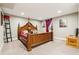 A grand wooden four-poster bed and modern artwork adorn this carpeted bedroom space at 14290 W 54Th Ave, Arvada, CO 80002