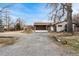 Charming single-story home with a stone and painted brick facade, a large driveway and an attached two-car garage at 14290 W 54Th Ave, Arvada, CO 80002
