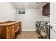 Laundry room includes a modern washer and dryer, dresser, and tiled floors at 14290 W 54Th Ave, Arvada, CO 80002