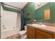 Cozy bathroom featuring a shower-tub combo and warm-toned vanity with complementary neutral countertop at 2019 S Fox St, Denver, CO 80223